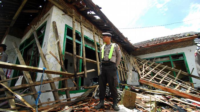 Indonesien Gewalt Ahmadiyah Muslime Polizist vor zerstörtes Haus
