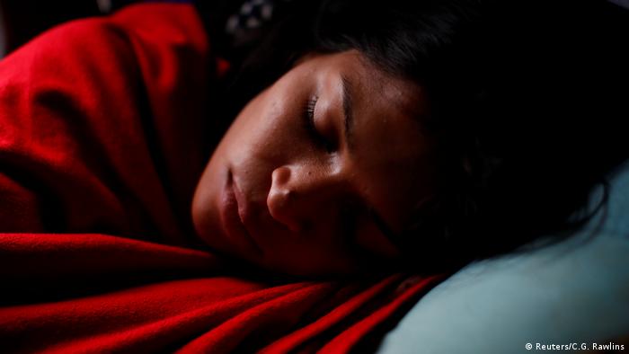 Alejandra Rodríguez duerme mientras viaja en el autobús rumbo a Chile, el 14 de noviembre de 2017. Finalmente, después de siete días de viaje atravesando cinco países, ha encontrado una posición cómoda para dormir en su asiento. O quizás estaba tan cansada que ya no le importaba cómo dormía.