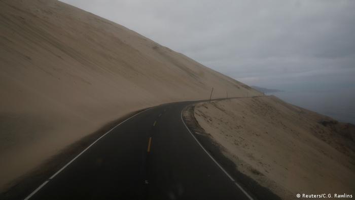 La carretera serpentea junto al mar en Atico, Perú, el 13 de noviembre de 2017, mientras Carlos García Rawlins disfruta de la vista desde la primera fila en el piso superior del autobús. Dijo sentir a veces un sentimiento de vacío mientras el camino desaparecía detrás de una curva y la niebla descendía, cubriendo el horizonte.