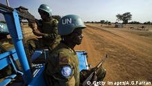 UN peacekeepers on patrol from the back of a car