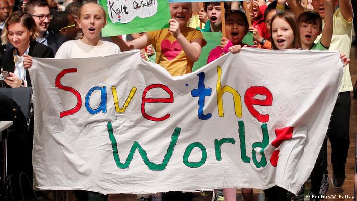 Children holding a Save the world banner (Reuters/W. Rattay)